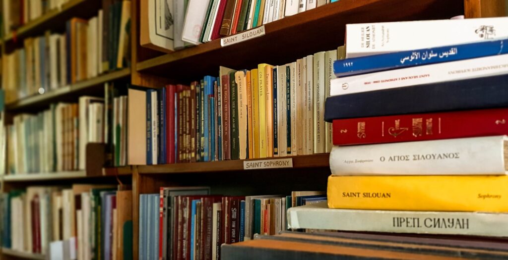 Monastery of St John the Baptist library scene with religious books stacked up on the foreground